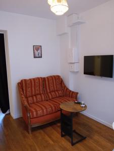 a living room with a brown couch and a table at la pomme d'amour in Sully-sur-Loire