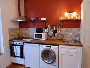 a kitchen with a washing machine and a microwave at la pomme d'amour in Sully-sur-Loire +5 photos