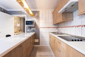 Una cocina con gabinetes de madera y un fregadero. en Home2Book Relaxing Coastal Apt with Terrace, en Puerto de la Madera