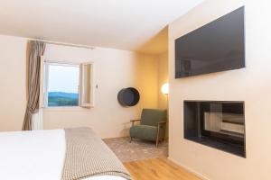 a bedroom with a bed and a television on a wall at Castello di Ribano Le Dimore in Savignano sul Rubicone