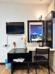 a hotel room with a desk and a mirror at Swiss Hotel at City Centre in Kuala Lumpur