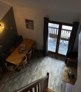 a dining room with a wooden table and a window at L'Ourson skis aux pieds in Valmeinier