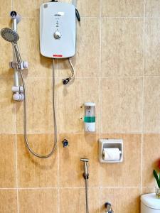 a shower in a tiled bathroom with a toilet at Swiss Hotel at City Centre in Kuala Lumpur