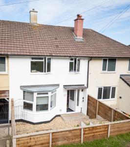 a white house with a fence in front of it at Contractor Accommodation Avonmouth 3 Bedroom House Sleeps 6 Free Van Parking in Avonmouth