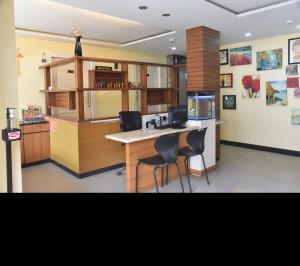 a kitchen with a counter and two chairs in a room at Mysore Central 3bhk serviced apartment in Mysore