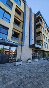 een gebouw met een parkeerplaats ervoor bij Airport Nest Skopje in Petrovec