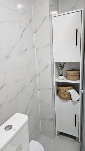 a bathroom with white marble walls and a toilet at Airport Nest Skopje in Petrovec