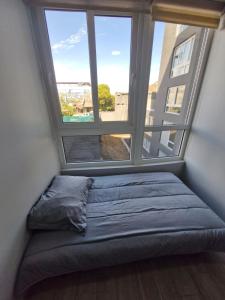una cama en una habitación con una ventana grande en Movistar Arena - Ohiggins Park - Parking, en Santiago