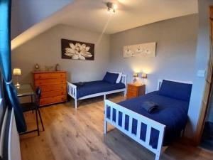 a bedroom with a blue bed and a dresser at Oaktree Manor - BBQ, games rooms and pet friendly in Castlewellan