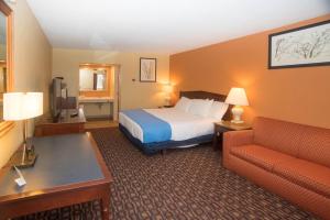 
a hotel room with a bed and a chair at Colonnade Inn in Lyndonville
