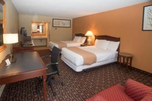 
a hotel room with a bed and a chair at Colonnade Inn in Lyndonville
