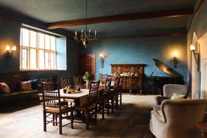 a dining room with a table and chairs and a piano at Sand Manor in Sidbury