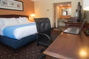 a hotel room with a bed and a desk with a laptop at Colonnade Inn in Lyndonville