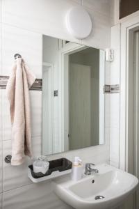 a white bathroom with a sink and a mirror at Omni Residence Vendégház in Bük +113 photos