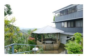 a building with a gazebo in front of it at Periyar Heritage Homes in Thekkady