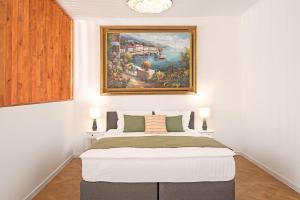 シビウにあるLUNA Residence Sibiu 1の壁に絵が飾られたベッドのある寝室