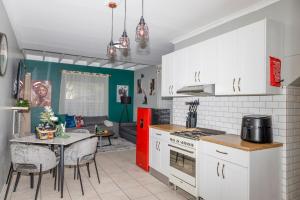 a kitchen with white cabinets and a red refrigerator at Home in Durbanville in Oakdale