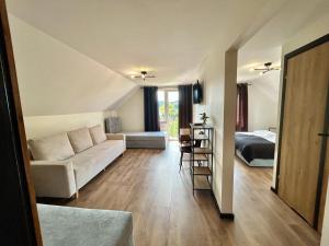a living room with a couch and a bed at Pokoje Gościnne Dudziński in Leśna