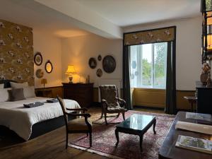 a bedroom with a bed and two chairs and a table at L'échappée belle in Sixt-sur-Aff