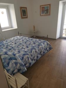 a bedroom with a bed and a chair and a window at Dimora Visconti in San Demetrio neʼ Vestini