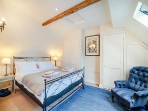 ein Schlafzimmer mit einem Bett und einem blauen Stuhl in der Unterkunft Kings Cottage North - Uk49855 in Broad Chalke + 10 Fotos