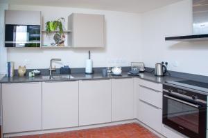 a kitchen with white cabinets and a sink at The Butler's Flat at Solsgirth Home Farm in Dollar