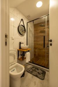 Un baño con inodoro, lavabo y ducha. en No Stress House, en Paul do Mar