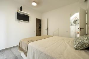 Un dormitorio con una cama y un televisor de pantalla plana. en No Stress House, en Paul do Mar
