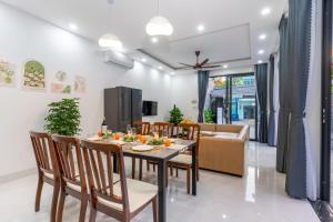 a dining room and living room with a table and chairs at Sunny Beach Villa in Danang