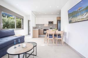 a living room with a blue couch and a kitchen at Villa Averto Anna in Ráchi