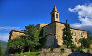 an old stone building with a clock tower on it at Torricella Hosting in Torricella