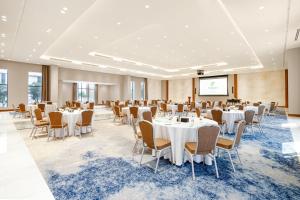 a conference room with tables and chairs and a projection screen at Holiday Inn Riyadh The Business District by IHG in Riyadh +62 photos