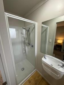 a bathroom with a shower and a sink at Casa Miguelle a Private 1br mini house in Dunedin