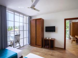 マーミギリにあるMaaniya Palaceのベッドとテレビ付きの客室と客室を提供しています。