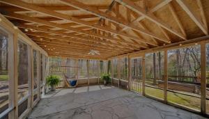 an empty screened porch with a wooden ceiling at Tranquilidad y todo cerca in Matthews