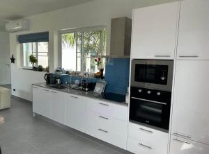 Ban Saiyuan (1)にあるVilla Guenlaur 3 studios with kitchenette and poolの白いキャビネットとコンロ付きオーブンを備えたキッチン