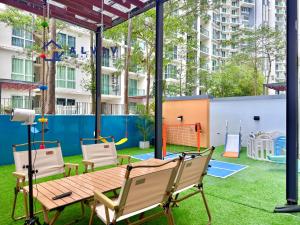 a patio with a table and chairs and a playground at NEW! The Shore Residences 3BR Luxury I Direct access to Shopping I 6-10pax I 10minsJonker in Melaka