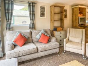 a living room with a couch and a chair at Glen View Lodge in Innerwick