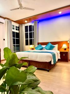a bedroom with a large bed with blue lighting at Maaniya Palace in Maamigili
