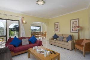 a living room with two couches and a table at Villa Curva do Monte by Villa Plus in Carvoeiro