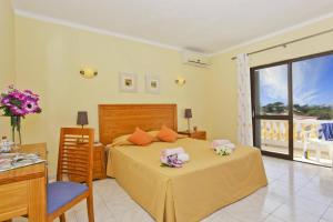 a bedroom with a bed with flowers on it at Villa Curva do Monte by Villa Plus in Carvoeiro +23 photos