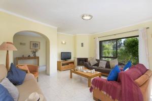 a living room with a couch and a tv at Villa Curva do Monte by Villa Plus in Carvoeiro