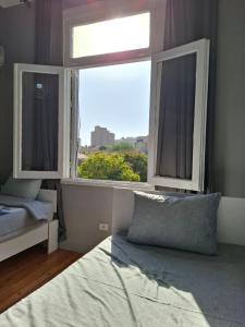 カイロにあるCairo Backpackers Central Hostelのベッドと大きな窓のある寝室