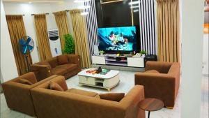 a living room with couches and a flat screen tv at Shortletbytee in Ikeja