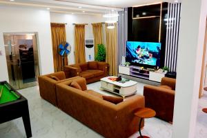a living room with couches and a flat screen tv at Shortletbytee in Ikeja