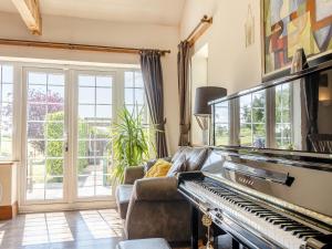 a living room with a piano and a couch at Oakdale Lodge in Hopwood