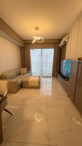 a large living room with a couch and a television at Z Loft Skyhouse BSD in Samporo