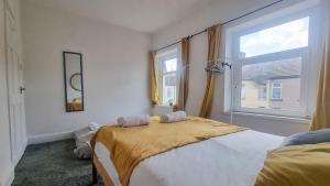 a bedroom with a bed and a window at Cosy bright 4 bed house 11mins from Cardiff centre in Cardiff