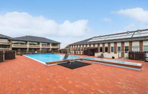 a large courtyard with a swimming pool in front of a building at Awesome Apartment In Fanø With Sauna in Fanø +9 photos