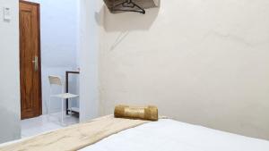 a bed with a gold purse sitting on top of it at Omah Sewu Sakura By Reccoma in Surabaya
